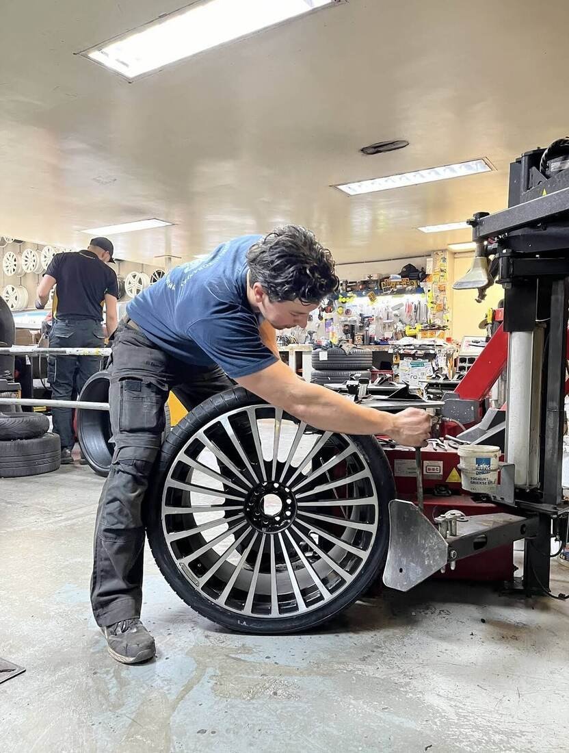 Don monteert een band op een grote lichtmetalen velg